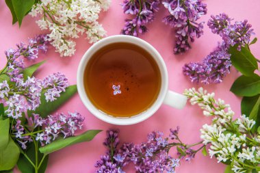 Pembe bir arka planda Lila çiçek ile çay fincan