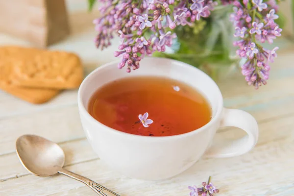 Thee en Blooming Lila, bloemblaadje in een kopje — Stockfoto