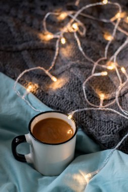 Yatakta kahve bardağı ve çelenk. Atmosferik İsveç Hygge tarzı