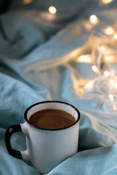 Φλιτζάνι καφέ και Γκάρλαντ σε ένα κρεβάτι. Ατμοσφαιρικό σουηδικό στυλ — Φωτογραφία Αρχείου