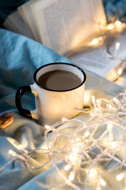 Yatakta kahve bardağı ve çelenk. Atmosferik Hygge tarzı. Rahat w