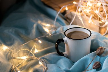 Yatakta kahve bardağı ve çelenk. Atmosferik Hygge tarzı. Rahat w