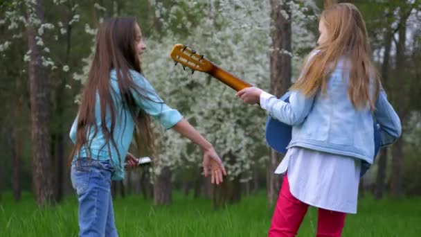 小女孩们在一起唱歌跳舞 一起玩吉他 在春天的林地里玩得开心 — 图库视频影像
