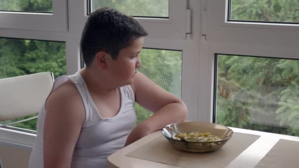 退屈脂肪少年のキッチン ダイニングのスープ 概念の幼年期の肥満 過食杯を食べる — ストック動画