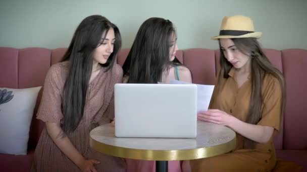 三活跃的女友看宣传海报和选择新的衣服在网上商店微笑和欢笑有乐趣 在线使用笔记本电脑和互联网 同时坐在咖啡厅 — 图库视频影像