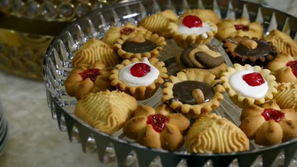 ボウルにチョコレートとおいしい甘いクッキー 明るくカラフルなお祝いビュッフェ式のクローズ アップ コレステロールや脂肪の概念 — ストック動画