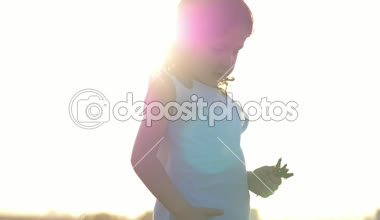 küçük kız eğlenceli tarlada karahindiba çiçekler toplar. Blossom zaman bahar yeni bir hayata başlamak. Çocuk dinlenme açık havada sağlıklı yaşam tarzı