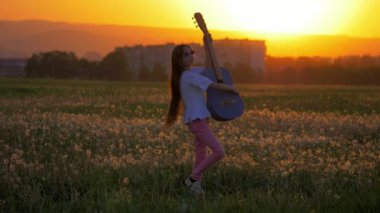 güzel genç kız açık havada şehrin arka plan üzerinde müzik. duygu ve daha komik palyaçoluk siluet günbatımı ışık tarafından. pop yıldız taklit