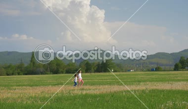 Dandelions alanında oynayan iki küçük neşeli kız kardeş. Eğleniyor, çayır kenti yakınlarındaki çalışan mutlu küçük kız. Çocuk gelişimi ve sağlığı kavramı