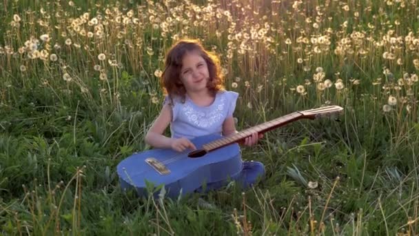 Divertida Niña Atractiva Sienta Hierba Toca Guitarra Jeans Campo Con — Vídeo de stock