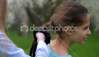 Görünüm elleri küçük kızın kız saç örgü veya örgü, yaşam tarzı dostane ilişkiler bağlama ile oynarken kapatmak