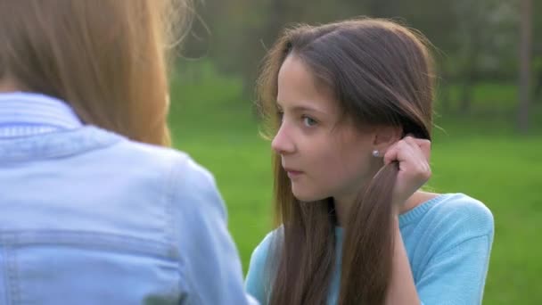 一个善于交际的年轻女孩与她的女朋友交谈和梳理头发做自己的头发的特写镜头 快乐和微笑 — 图库视频影像
