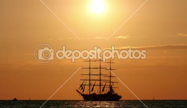 günbatımı güzel siluet yelkenli gemi sırasında denizin içinde. Üç direkli gemi denizde yüzen
