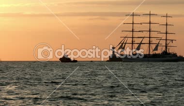 Gün batımında denize yakın bir daha küçük çekici tekne fenerinde geçmiş tarihsel uzun gemi yineleme schooner yüzen