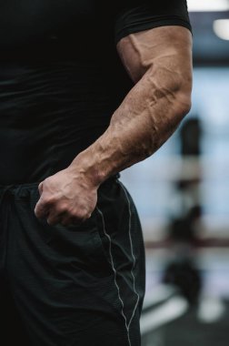 Vücut fiziği testesteron konsepti siyah spor giyimli güçlü erkek giyiminin spor yaparken büyük damarlı güçlü kolları gösteren bir parçası.