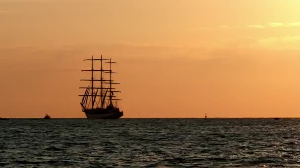 Egy Gyönyörű Háromárbocos Hajó Sziluettje Úszik Kikötőből Este Narancs Szín — Stock videók