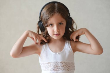 güzel beyaz çocuk şarkı söyleyip dans ediyor siyah kulaklıkla ev hapsi süresince müzik dinliyor.