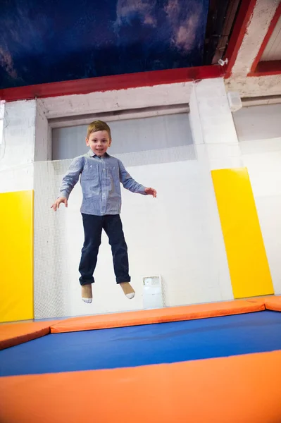Heureux mignon sain petit garçon sautant sur un trampoline à l'intérieur — Photo