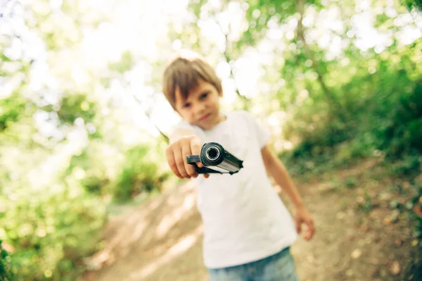 Опасный маленький кавказский паренек с пистолетом целится в камеру. — стоковое фото