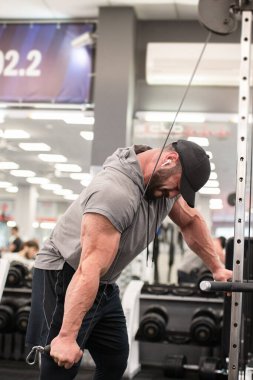 Genç sakallı güçlü sporcu erkek spor salonunda spor yaparken ağırlık kaldırma hobisi