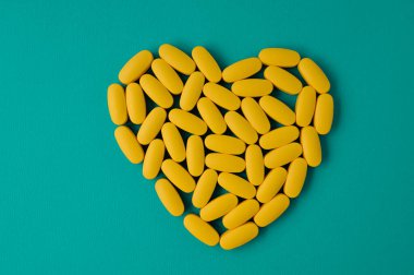 Kardiyo eczane sağlık hizmetleri konsepti. Kalp tabletlerinde bulunan sarı haplar.
