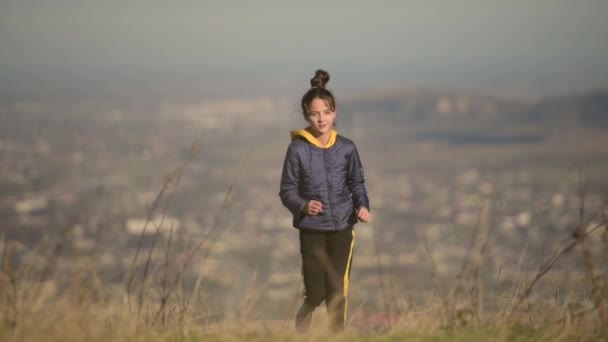 Giovane bambina in giacca correre all'aperto natura in autunno durante attività sportive per il tempo libero — Video Stock