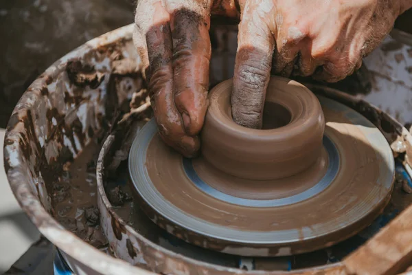 Master hands makes a pot of clay. The master class is held in nature.