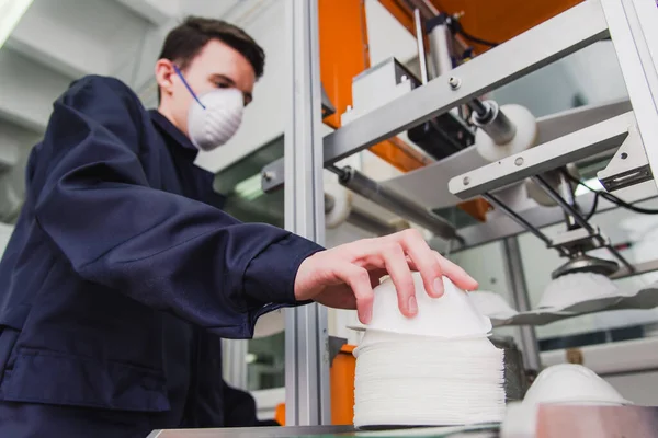 The guy works in a factory for the manufacture of medical masks with nanofiber. Coronovirus and Covid-19 Protection