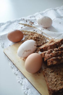 Çiftlikten taze organik çiğ tavuk kahverengi yumurta ve Keten tohumları ile sıcak tahıl ekmeği. Sağlıklı diyet.