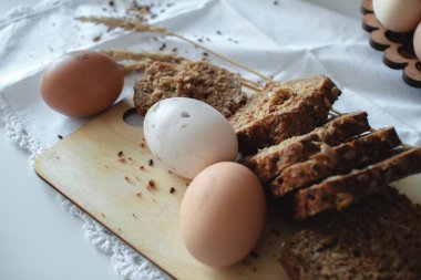 Çiftlikten taze organik çiğ tavuk kahverengi yumurta ve Keten tohumları ile sıcak tahıl ekmeği. Sağlıklı diyet.