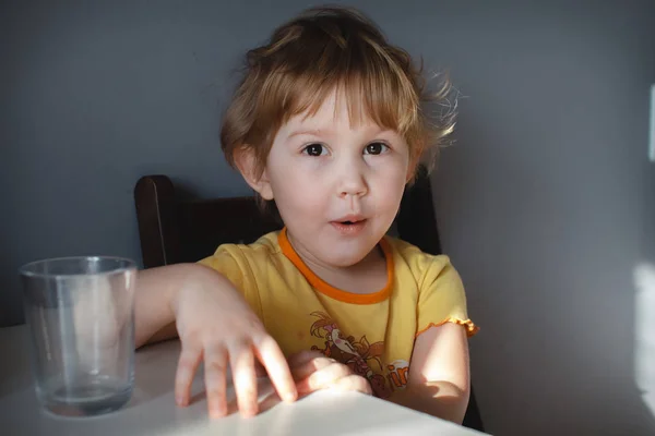 Retrato de uma criança engraçada em um fundo cinza na mesa de close-up. Palhaçadas engraçadas — Fotografia de Stock