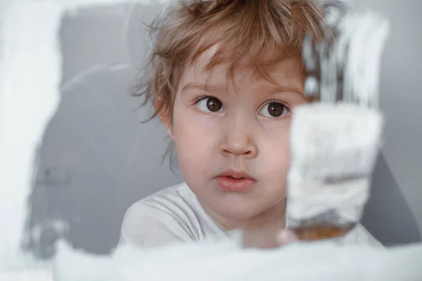 A criança desenha uma pintura branca em uma tábua de vidro. Tela simulada. Criança feliz com escova — Fotografia de Stock