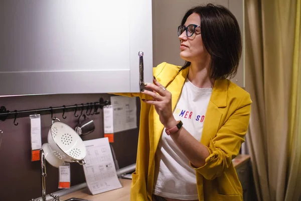 De planning van de keuken. Jonge vrouw huisvrouw kiest keuken meubilair te kopen in de winkel. Het concept van verkoop — Stockfoto