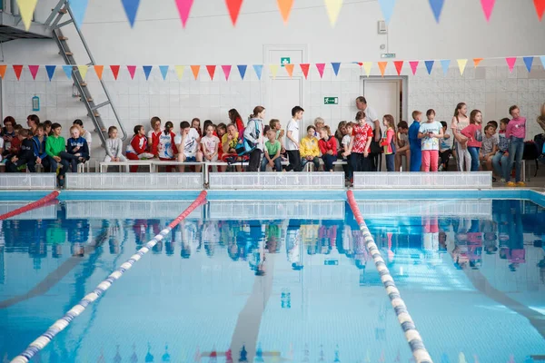 Russland, nowosibirsk, 26 mai 2019. die schwimmwettbewerbe begannen. Viele Kinder schwimmen und planschen im Becken. Aufwärmen vor dem Rennen. — Stockfoto