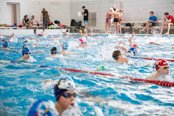 Russland, nowosibirsk, 26 mai 2019. die schwimmwettbewerbe begannen. Viele Kinder schwimmen und planschen im Becken. Aufwärmen vor dem Rennen. — Stockfoto