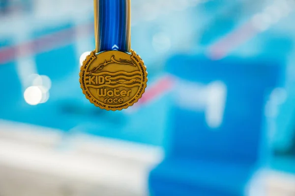 Rusya, Novosibirsk, 26 Mayıs 2019. Rekabet Su Çocuklar . Bulanık su arka planında altın madalya — Stok fotoğraf