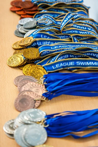 Ryssland, Novosibirsk, 26 maj 2019. Konkurrensen barn av bevattnar. Många guld-, silver-och bronsmedaljer finns på bordet. — Stockfoto