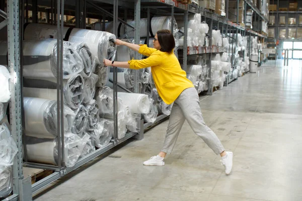 Meisje met bril neemt een groot en zwaar matras in de winkel. Groothandel en aankoop. Self-service magazijn. Selectie van producten — Stockfoto