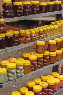 Çiftlik pazarında taze organik bal bulunan bir sürü kavanoz. Altai 'de bir pazarda renkli bal.