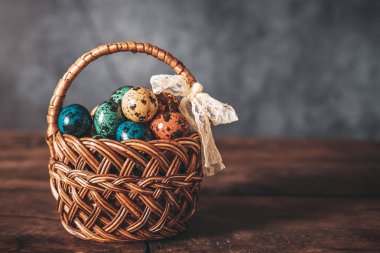 Çok renkli perpelina yumurta gri bir arka plan üzerinde bir Paskalya sepeti.