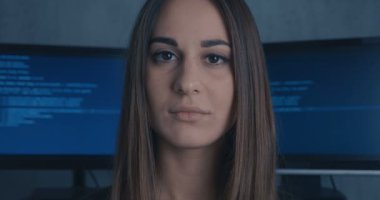 Genç kadın geliştirici ikili kod arka plan kameraya bakarak programcı