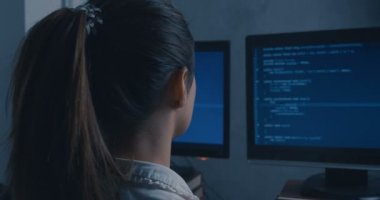 Genç kadın Hacker bilgisayar vasıl gece, arka yüzüne görünümü üzerinde programcı