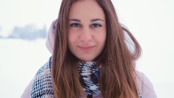 Cara de linda mujer joven en invierno al aire libre, de cerca. Invierno, nieve cayendo — Vídeos de Stock