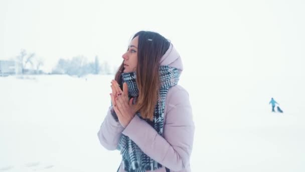 Increíble mujer tratando de calentar sus manos congeladas con un aliento en invierno mañana al aire libre . — Vídeo de stock