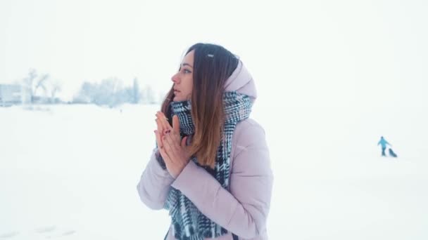 Geweldige vrouw wilt haar bevroren handen met een adem in winterochtend buiten Warm. — Stockvideo