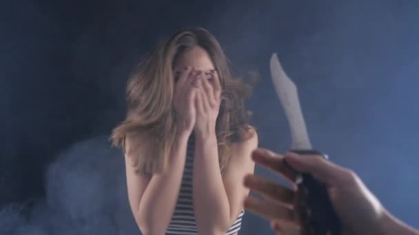 Maniak mengancam gadis itu dengan pisau. Situasi tanpa harapan. Ancaman kehidupan. Gadis itu menutup matanya dengan tangannya . — Stok Video
