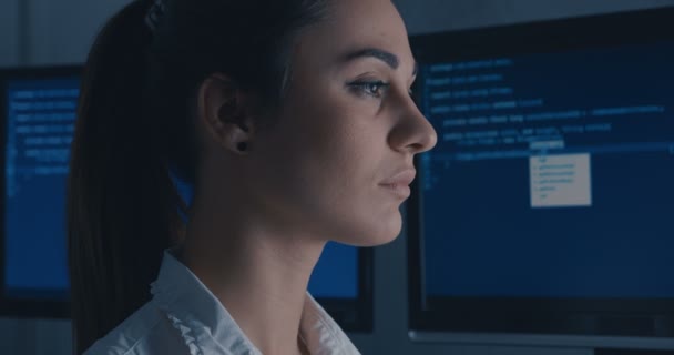 Jonge vrouw Hacker programmeur werken op de computer bij nacht, achterzijde view. Close-up van portret in profiel — Stockvideo