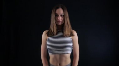 Çizgili üst baştan çıkarıcı kız duman karanlık bir odada duruyor.