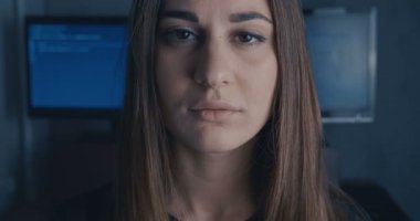 ciddi genç kadın geliştirici ikili kod arka plan kameraya bakarak programcı