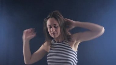 Çekici genç neşeli kadın karanlık odada dans eğlenceli var. O saç sallıyor.